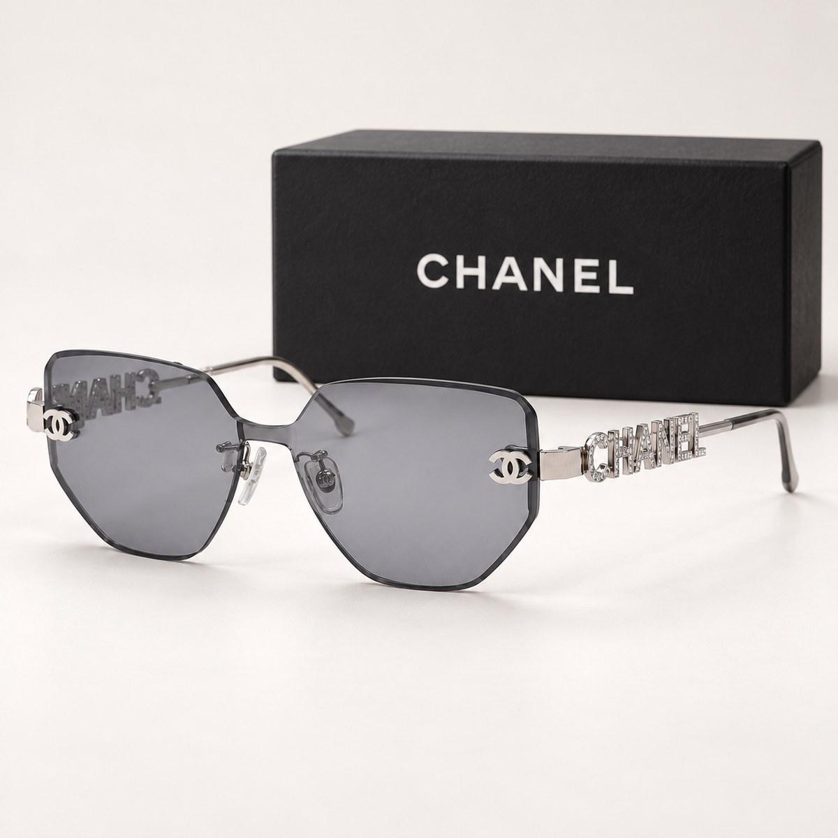 CC Silver Grey Rimless Geometric Sunglasses — front-left view with brand box